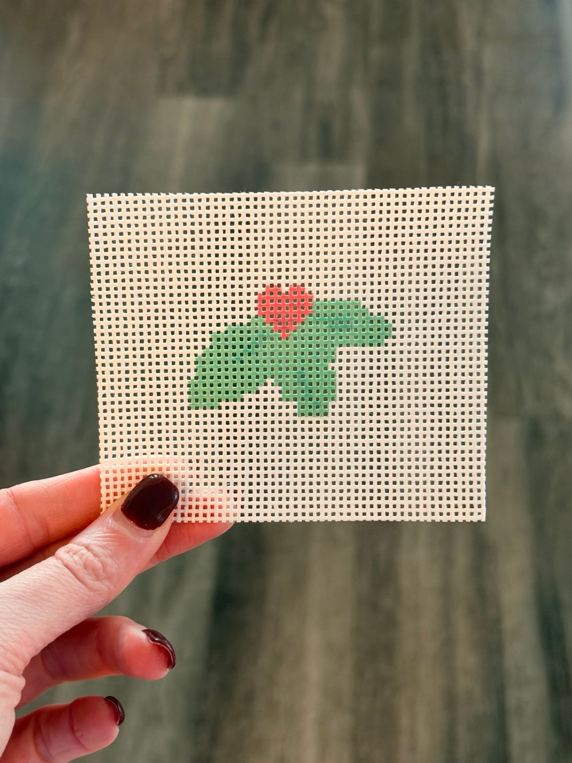 Holly Sprig Stitch Snacks mini, unstitched printed 13-mesh needlepoint canvas held in hand